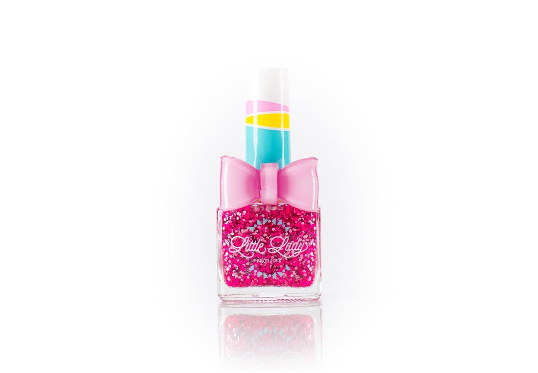 hot pink glitter nail polish with larger pieces of confetti. pink bow ring ontop of the nail polish bottle. 