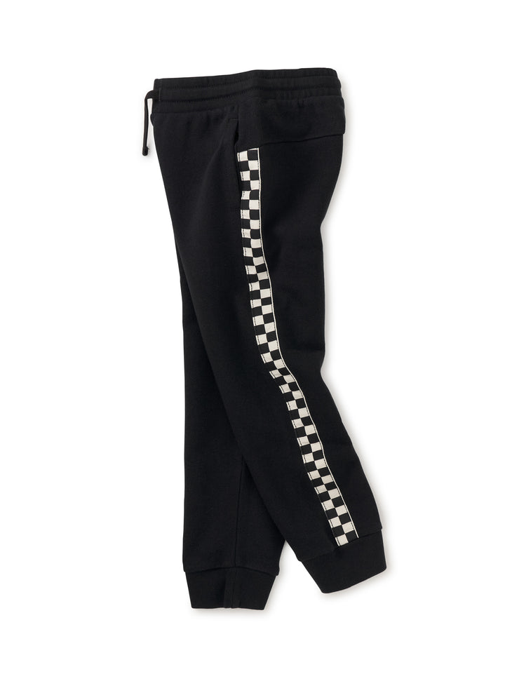 Black sweatpants with checkered side panels on a white background