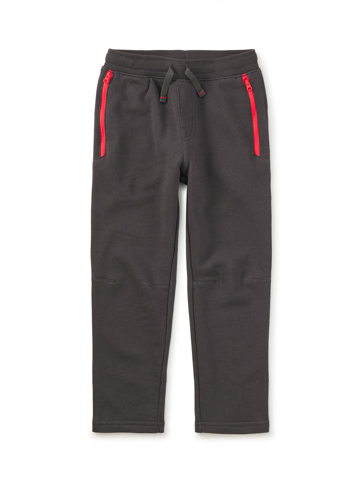 Dark gray sweatpants with red zippers on a white background