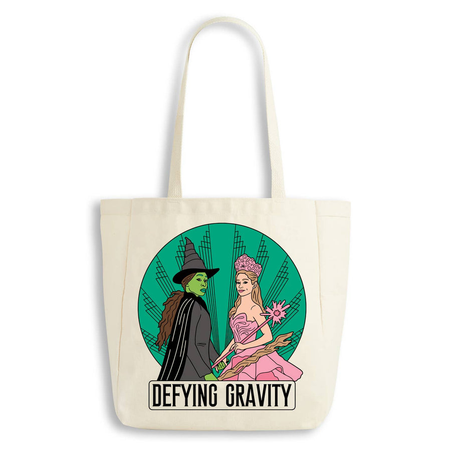 Tote bag with 'Defying Gravity' design featuring characters from a famous musical on a white background