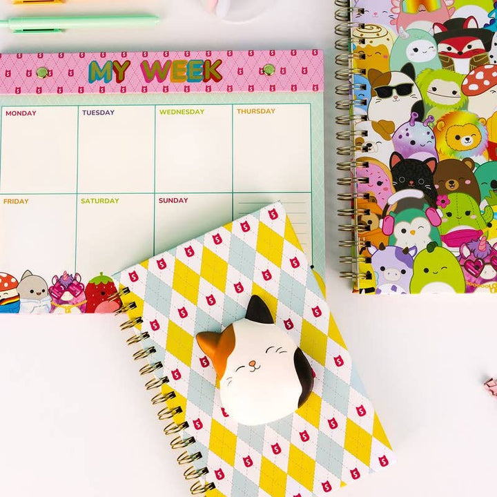Three colorful planners with different designs on a white background