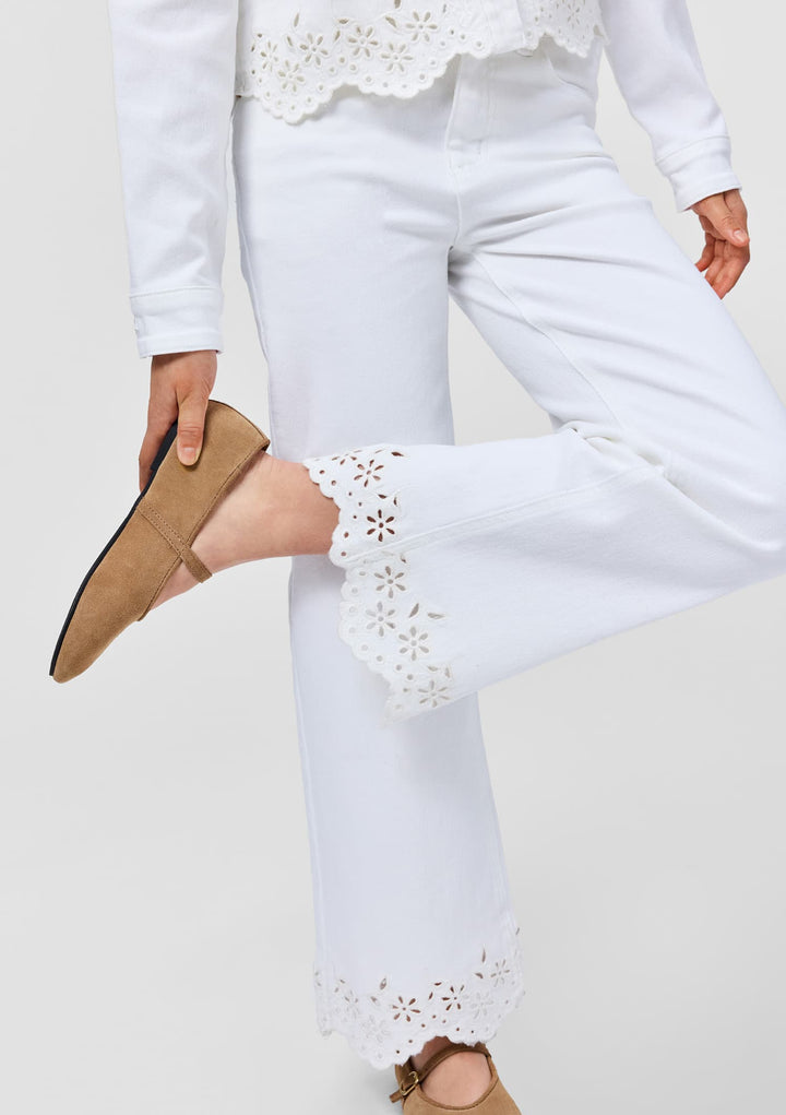 White pants with lace detailing worn by a person on a white background