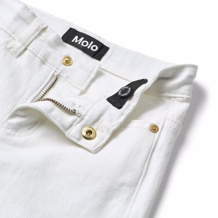 Close-up of white jeans with a Molo label on a light background