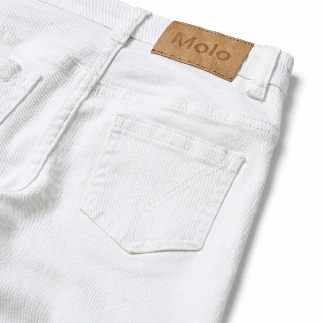 Close-up of white jeans with a Molo label on a light background