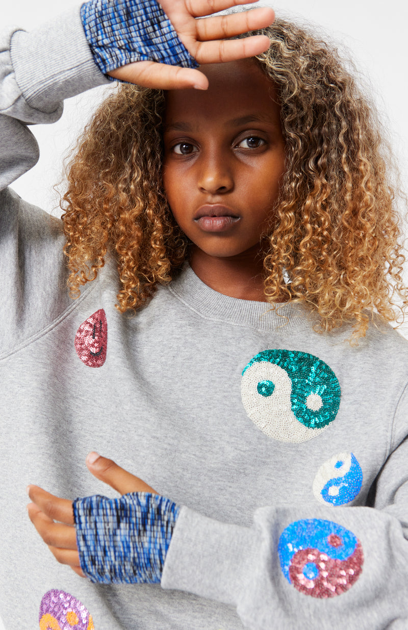 Girl modeling the Marge Grey Melange Sweatshirt with Ying and Yang Patches from Molo