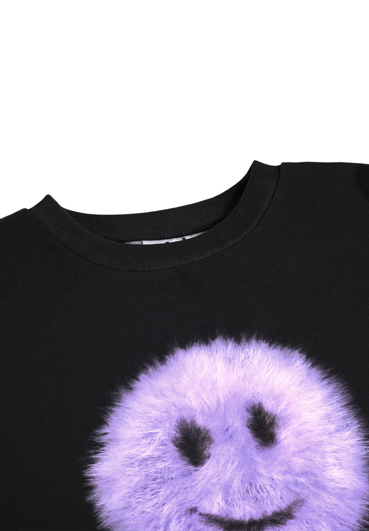 Close-up of a black crewneck shirt featuring a large, fuzzy lavender-purple smiley face graphic on the front.
