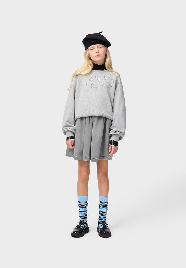 Person wearing a gray outfit with a black beret on a white background