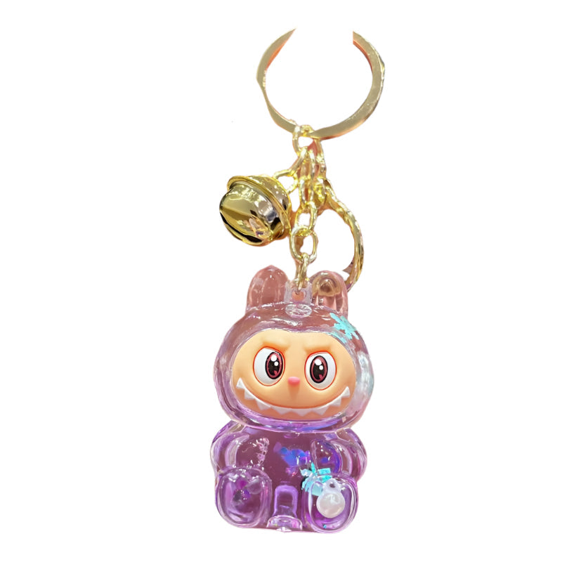 labubu inpired keychain attached to a gold ring. clear labubu keychain with purple glitter and confetti inside the charachter