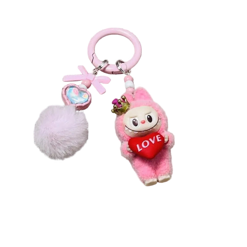 Pink figure keychain with a character holding a 'LOVE' heart on a textured beige background