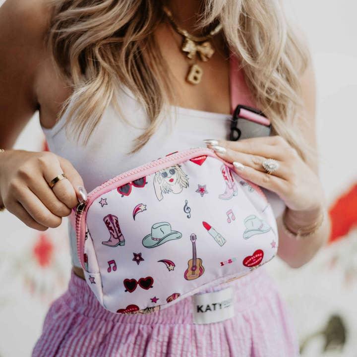 Girl modeling belt bag as a crossbody across her chest. this picyture helps to showcase the Taylor Swift print. 