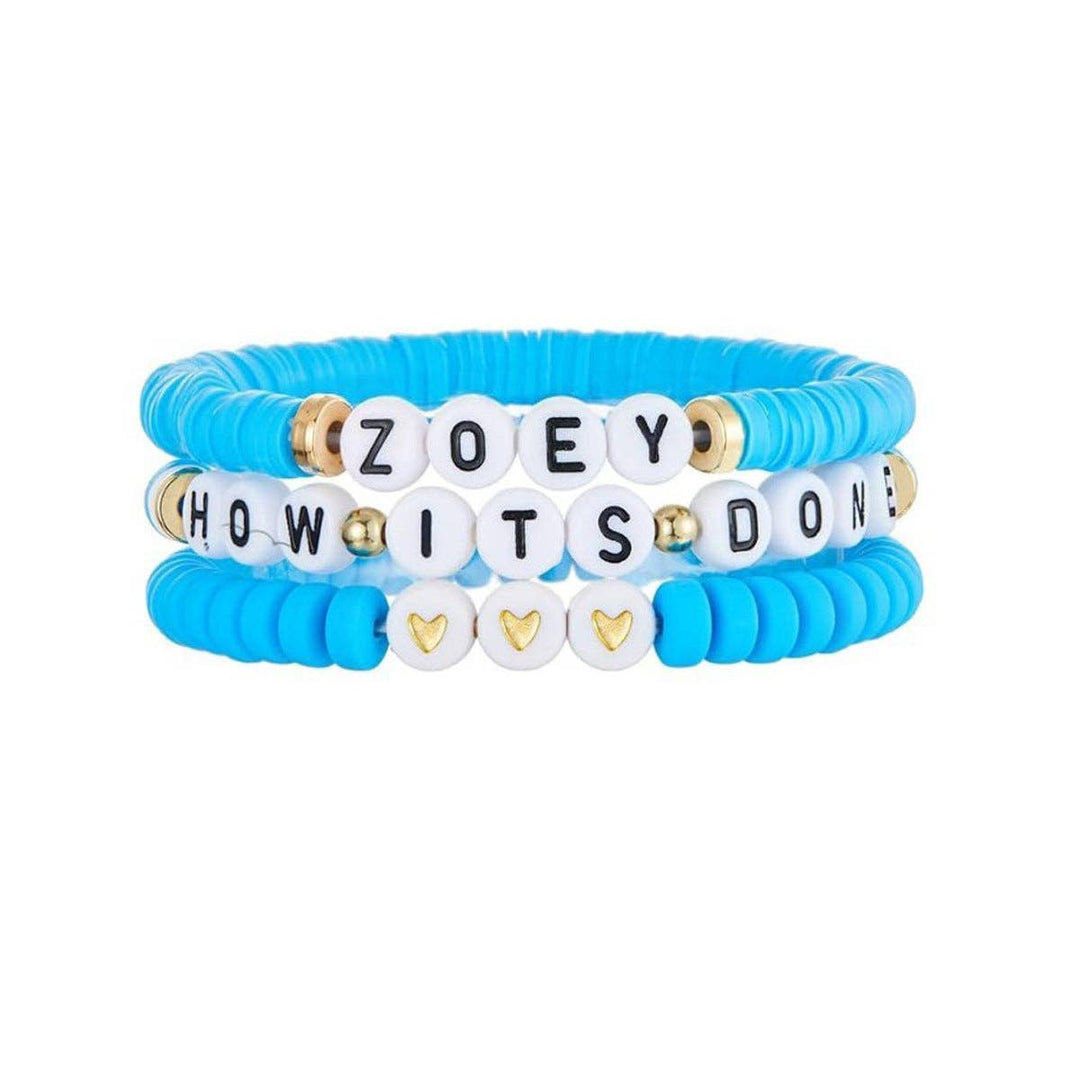 Set of blue and white beaded bracelets with personalized text on a white background
