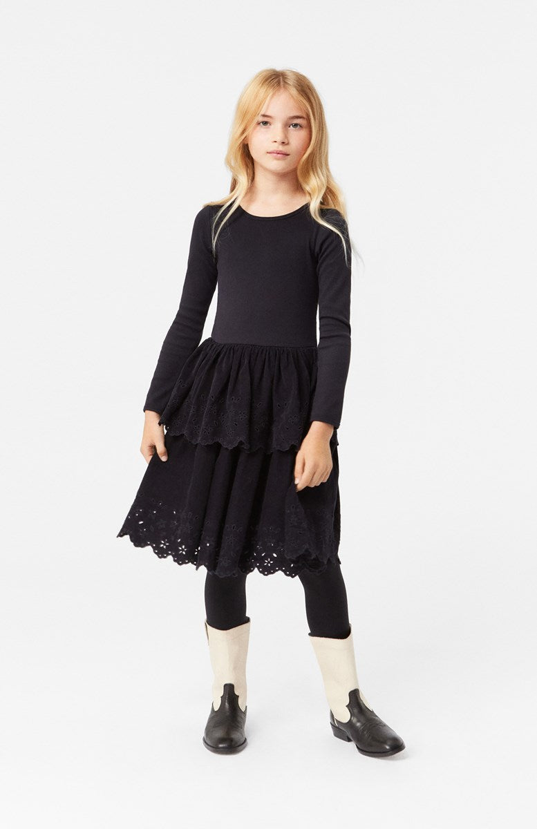 Girl wearing Molo Cerena Long Sleeve Round Neck Black Dress with Corduroy Skirt with Floral Cutouts.