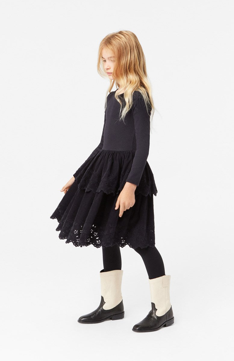 Girl wearing Molo Cerena Long Sleeve Round Neck Black Dress with Corduroy Skirt with Floral Cutouts.