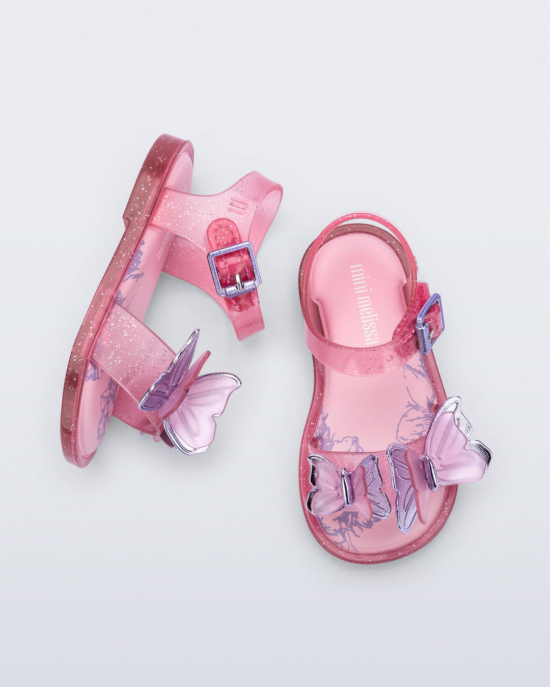 Pink children's sandals with butterfly designs on a light gray background
