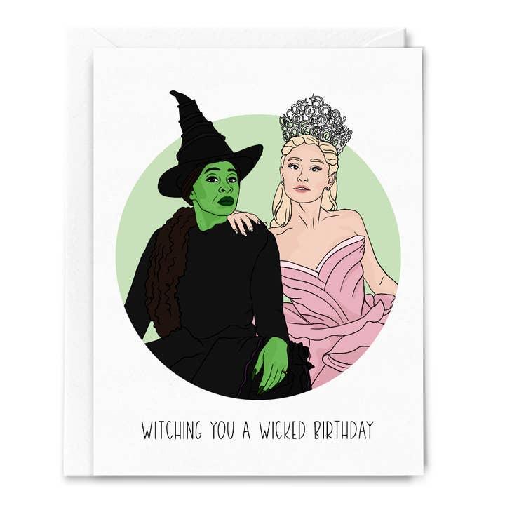 Greeting card with two illustrated characters, one in a witch costume and the other in a princess dress, with text 'Witching you a Wicked Birthday'.