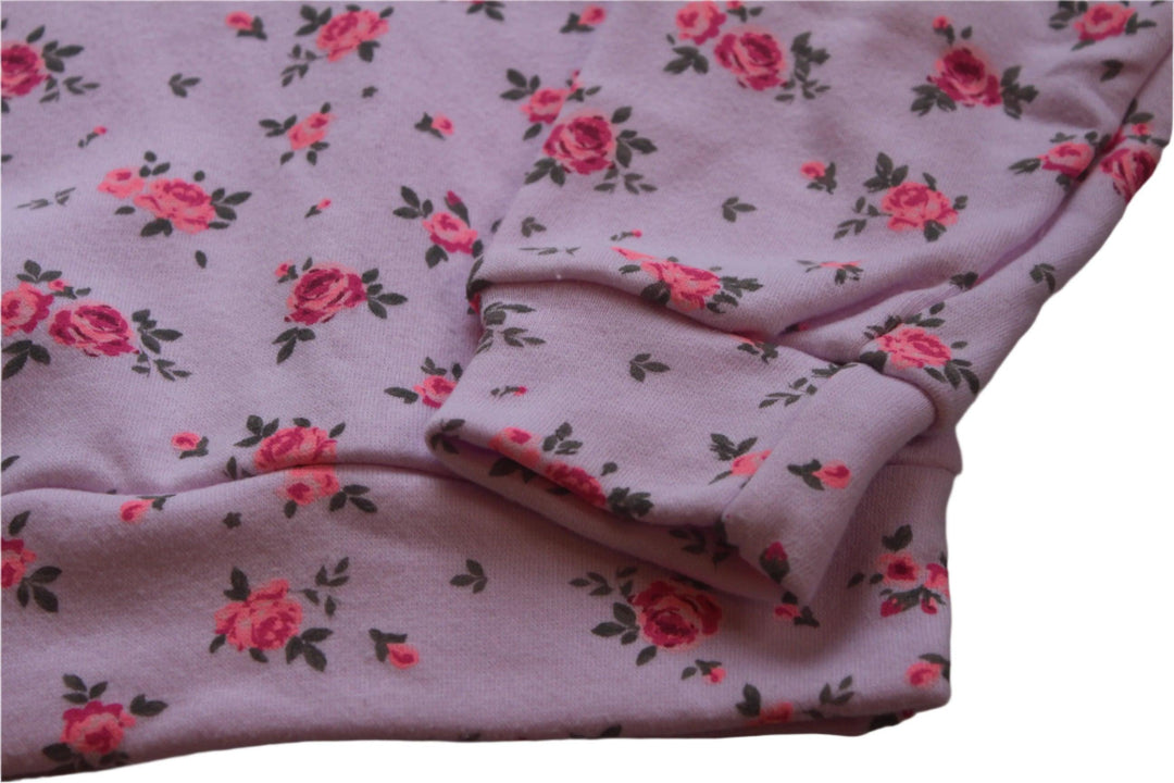 close up of the print on the pink sweatshirt and tiny pink roses all over it. 