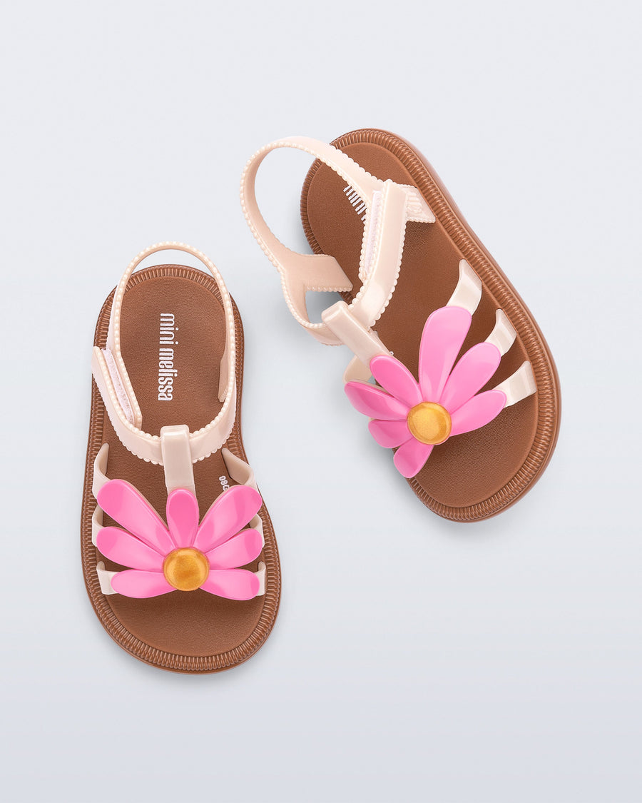 Children's sandals with pink flower decorations on a light blue background