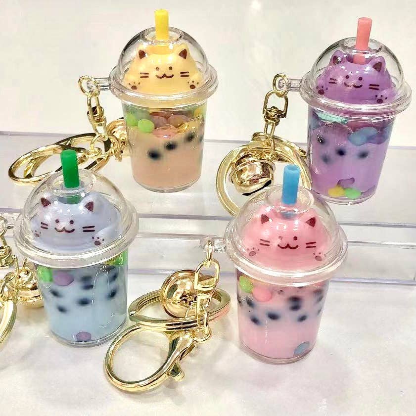 Cute keychains shaped like bubble tea cups with cat faces on a white background
