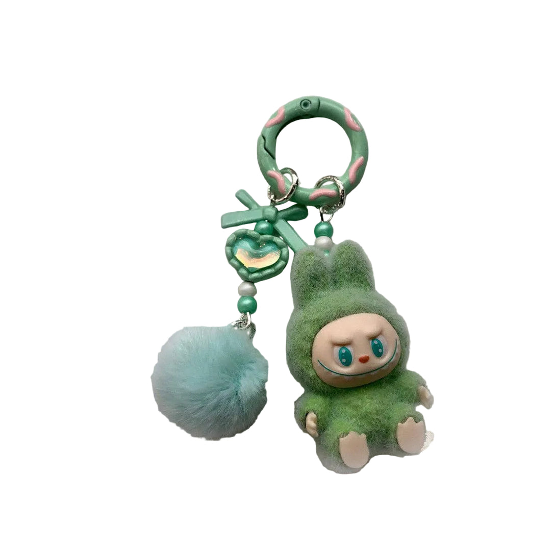 Green plush keychain with a pom-pom on a gray background