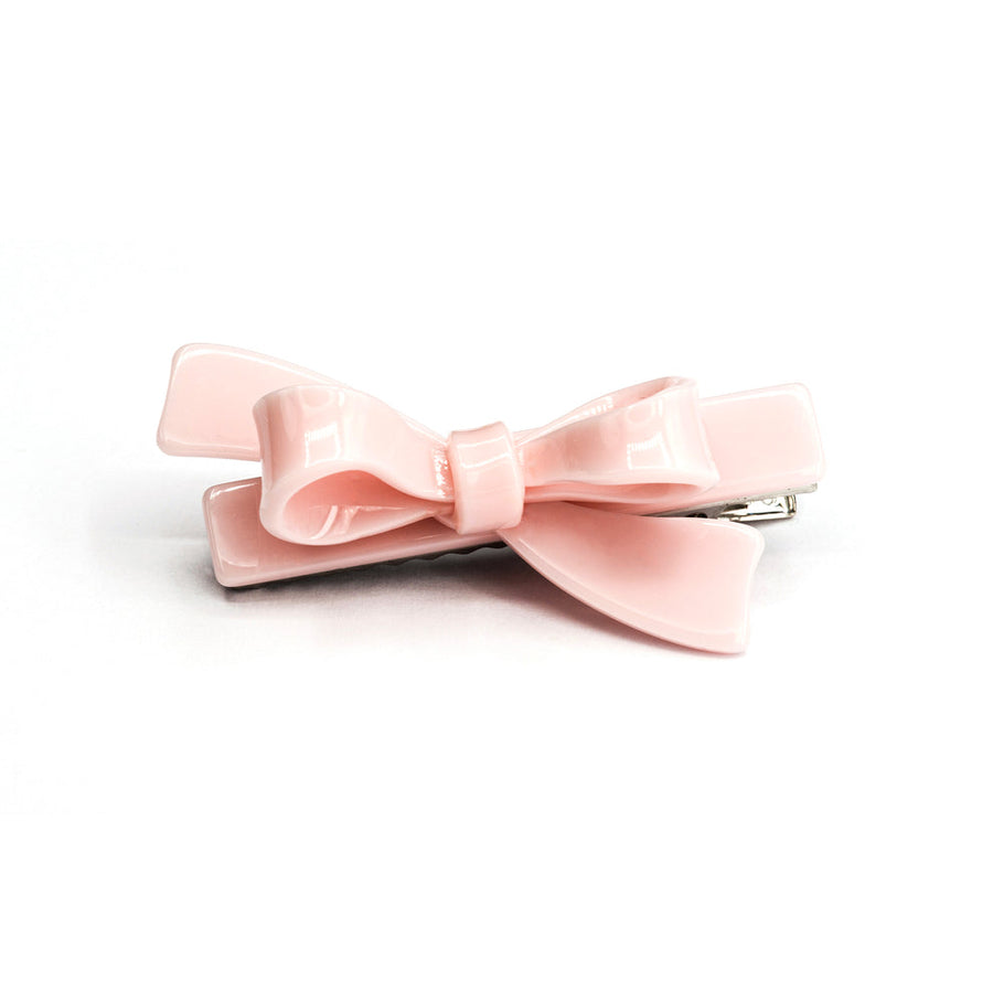Pink bow hair clip on a white background