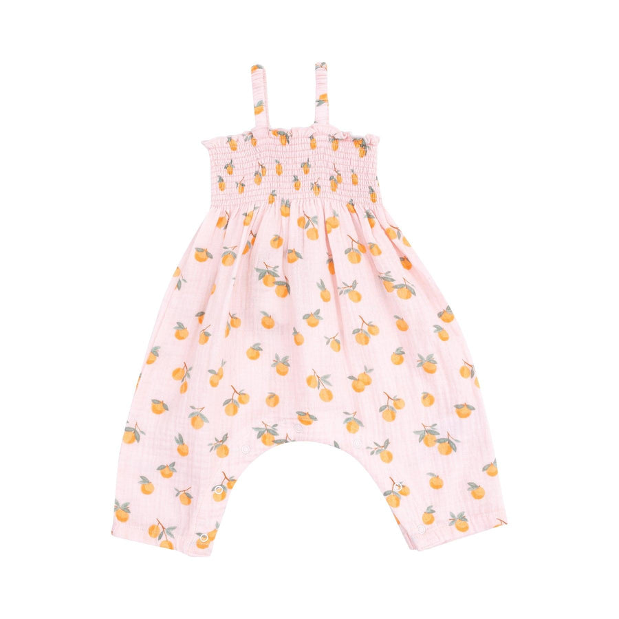 pink smocked romper with tiny oranges printed all over it with spaghetti straps and easy access for diaper changes