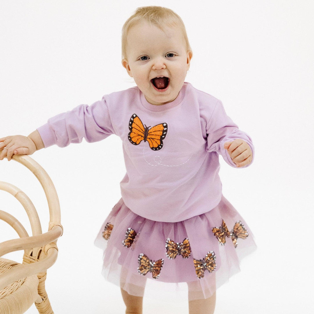 baby modeling the monarch butterfly tutu and sweasthirt with butterfly applique. 