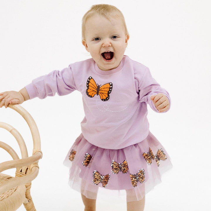 baby modeling the monarch butterfly tutu and sweasthirt with butterfly applique. 