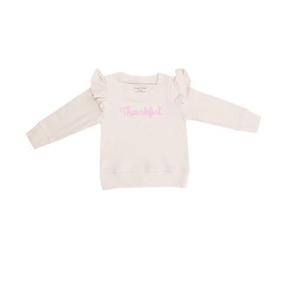 beige waffle top with ruffles at the shoulder, thankful written across the chest in light pink. 