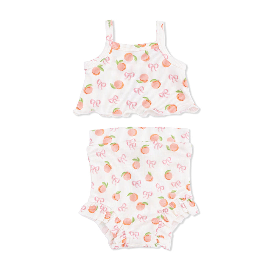 Two-piece baby girl set with Little Peaches and bow pattern on a white background