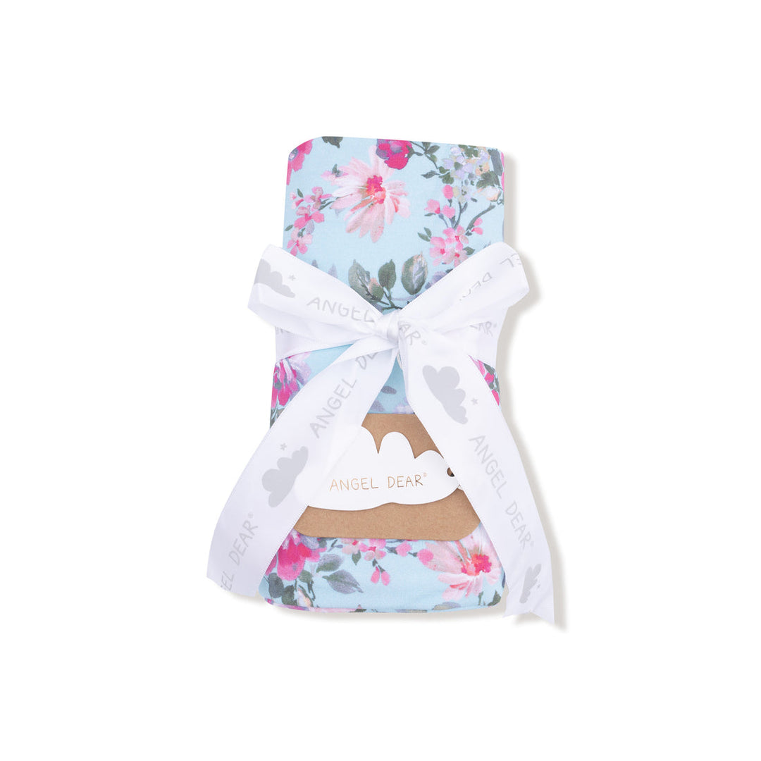 Floral-patterned baby blanket with a white bow on a white background