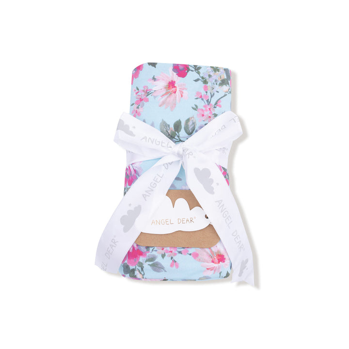 Floral-patterned baby blanket with a white bow on a white background