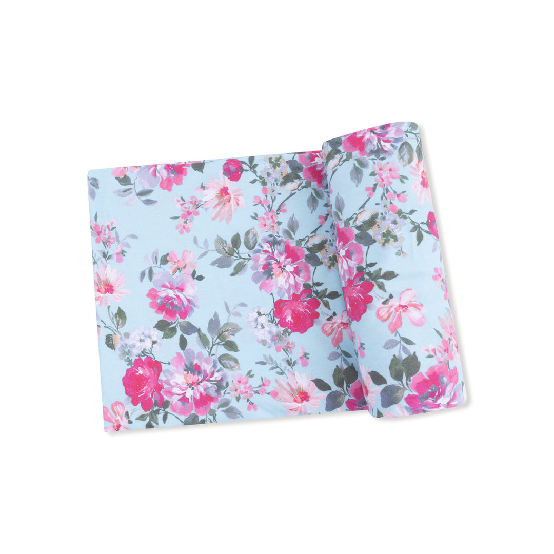 Floral baby swaddle with pink and green flowers on a light blue background