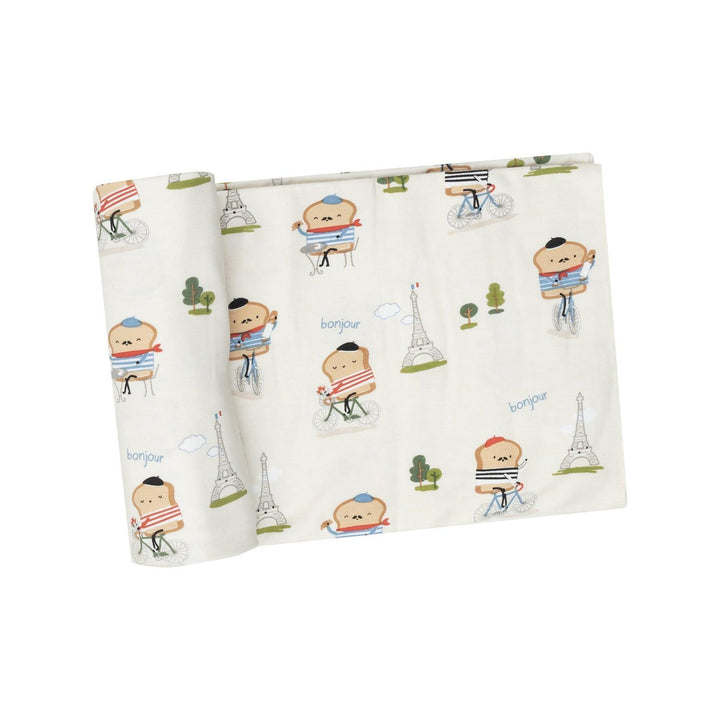 ivory swaddle with pieces of toast riding bicycles in front of the Eiffel Tower looking French