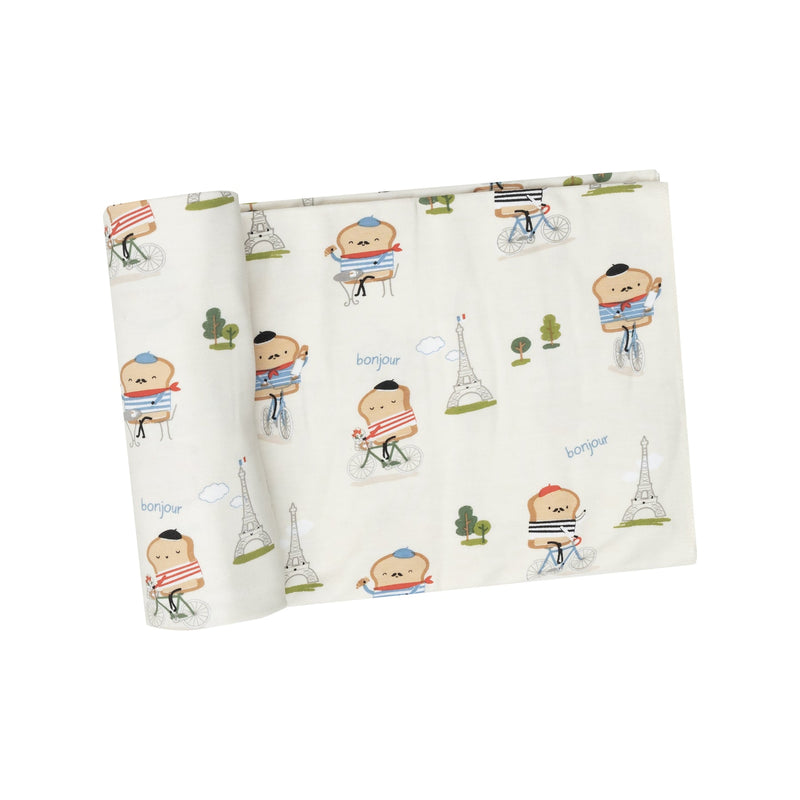 ivory swaddle with pieces of toast riding bicycles in front of the Eiffel Tower looking French