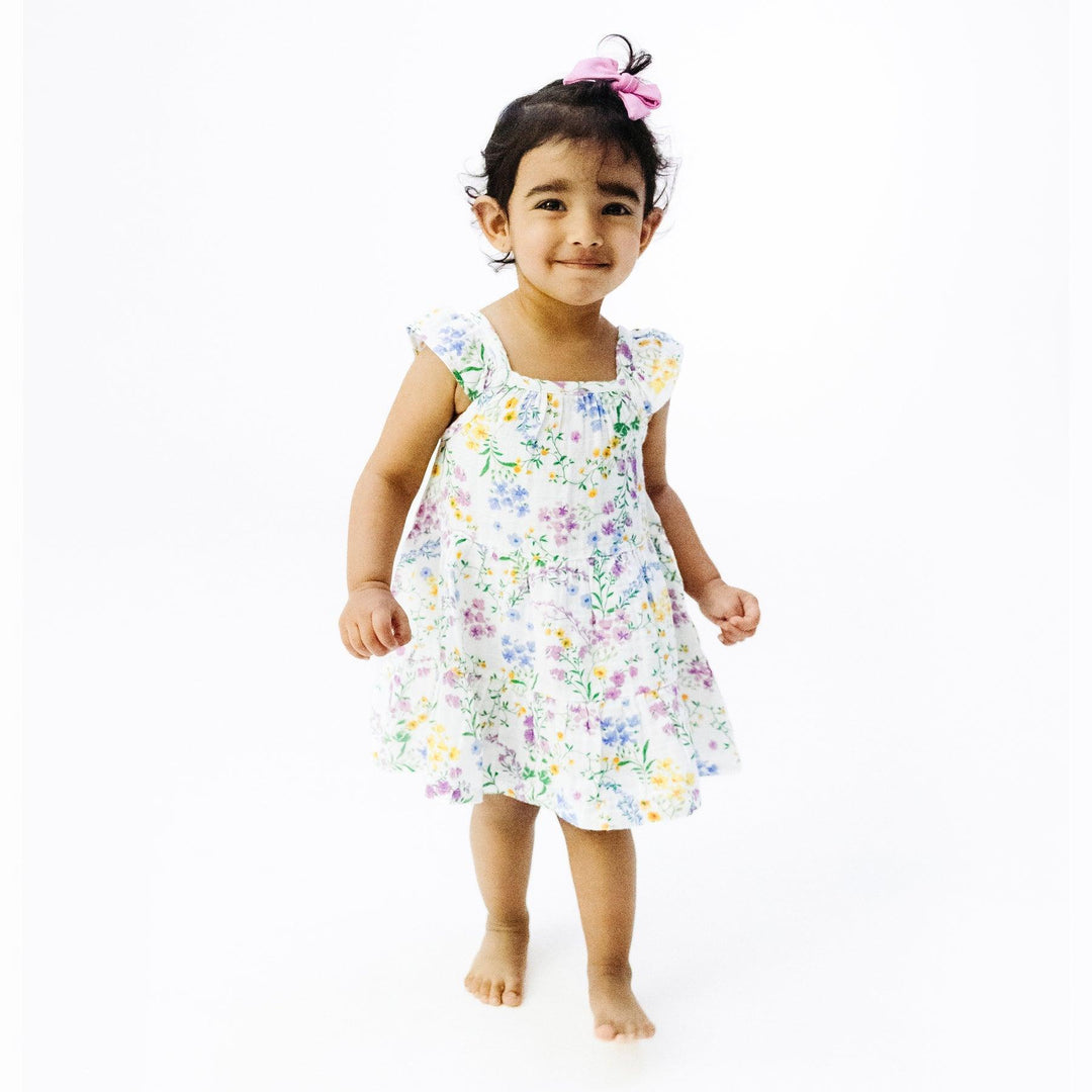 little girl modeling the tin floral dress. the dress hits the child at the knee. 