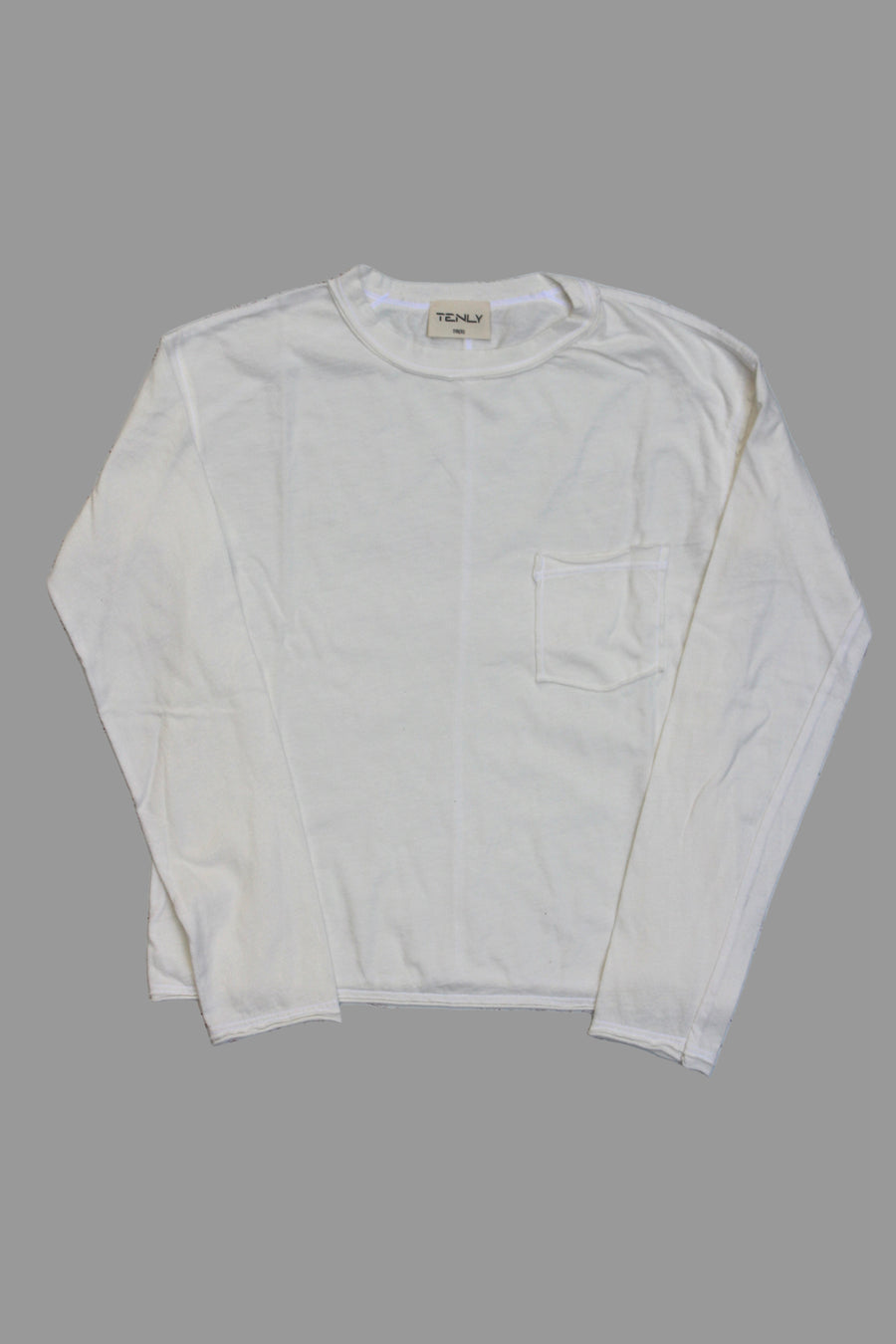 White long-sleeve shirt on a light wooden surface