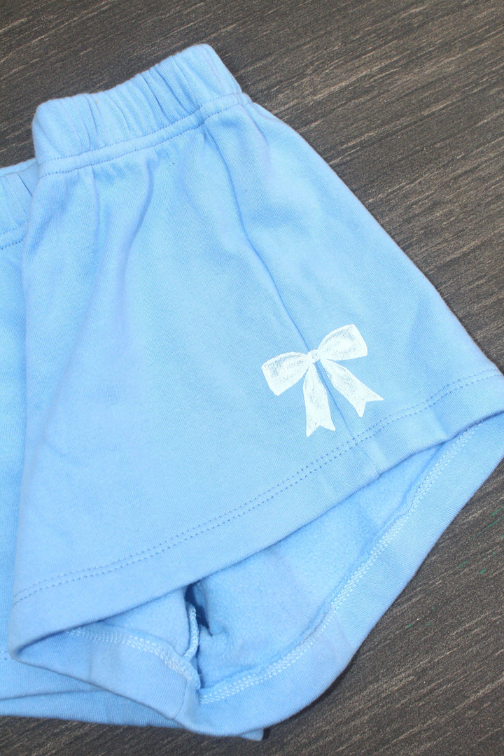 baby blue shorts with white bow accent on the shorts. 