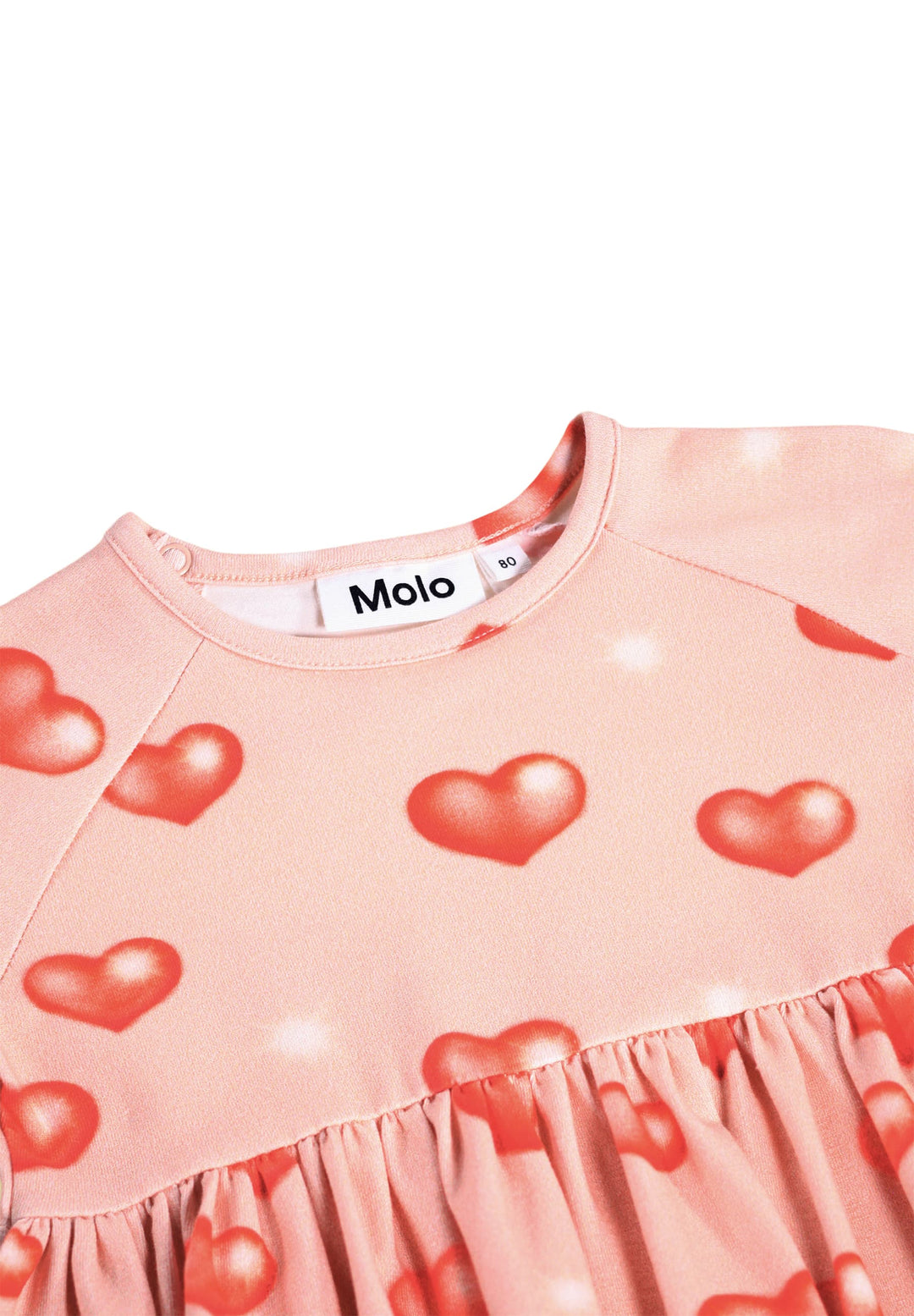 Pink dress with red heart patterns and Molo label on a white background