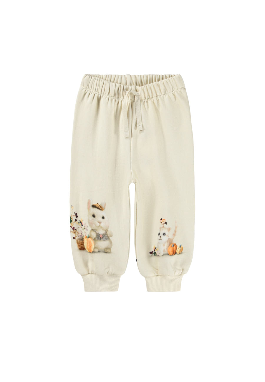 Cream-colored jogger pants with cute animal illustrations and small orange pumpkins on the lower legs, featuring an elastic waistband and drawstring.
