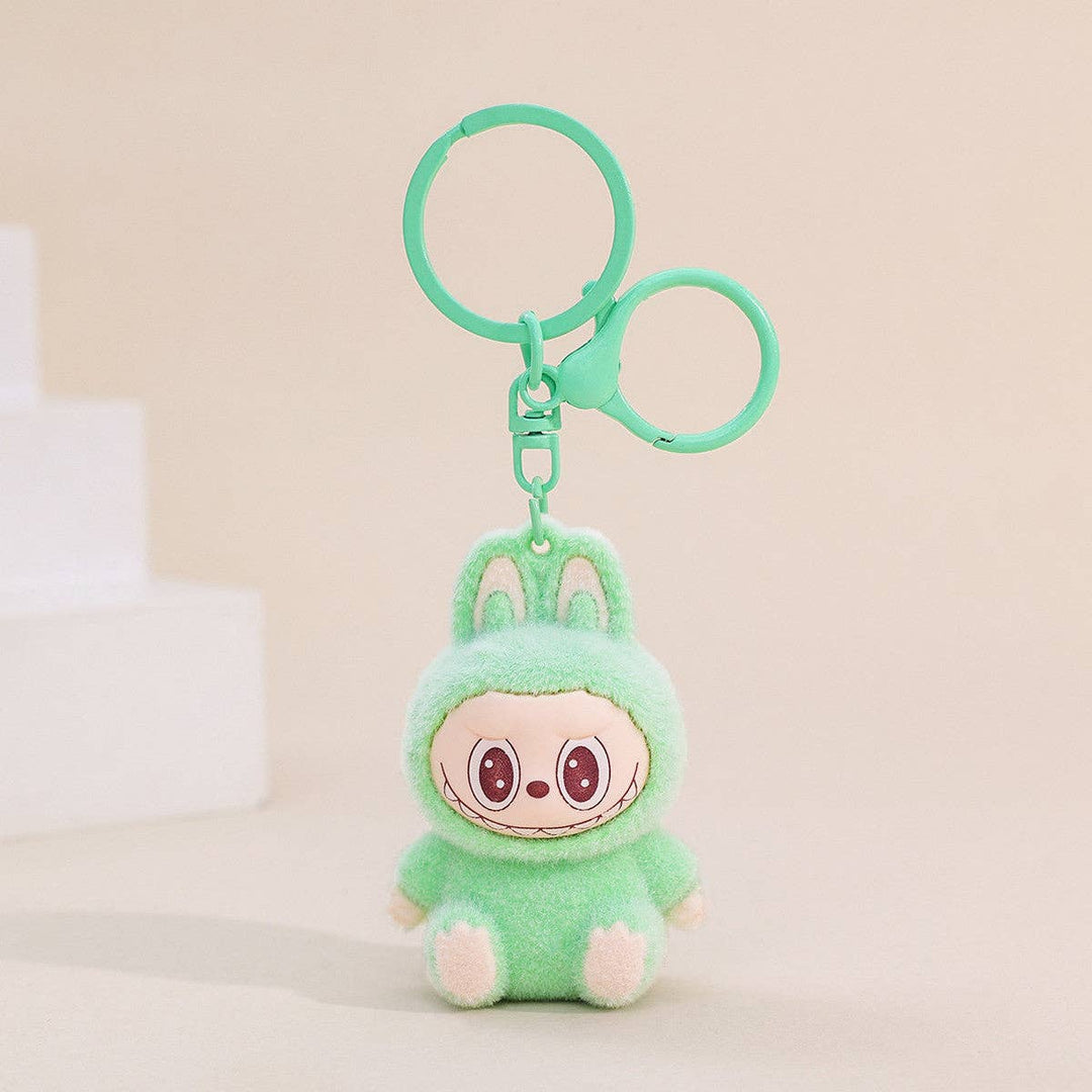 Plush keychain with a character in a green outfit on a beige background