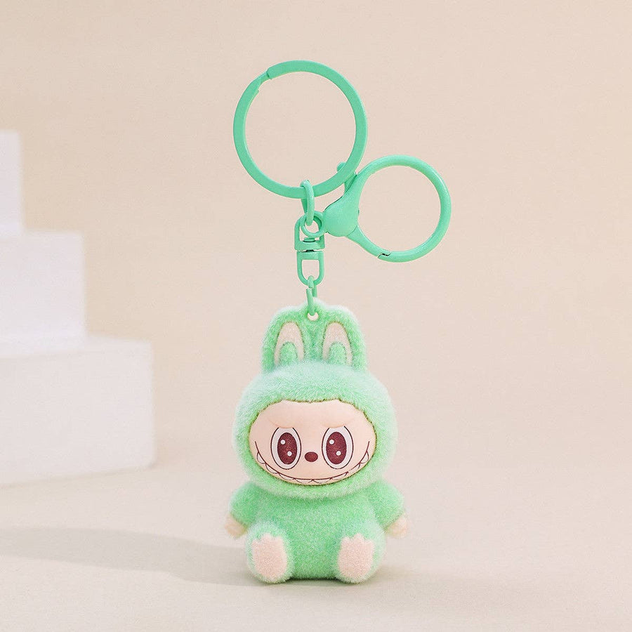 Plush keychain with a character in a green outfit on a beige background