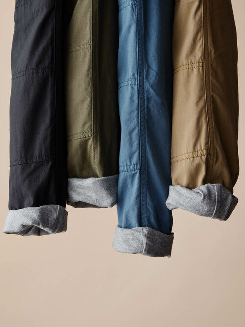Four pants in navy, green, blue, and brown, rolled up to see the lining of the pants 