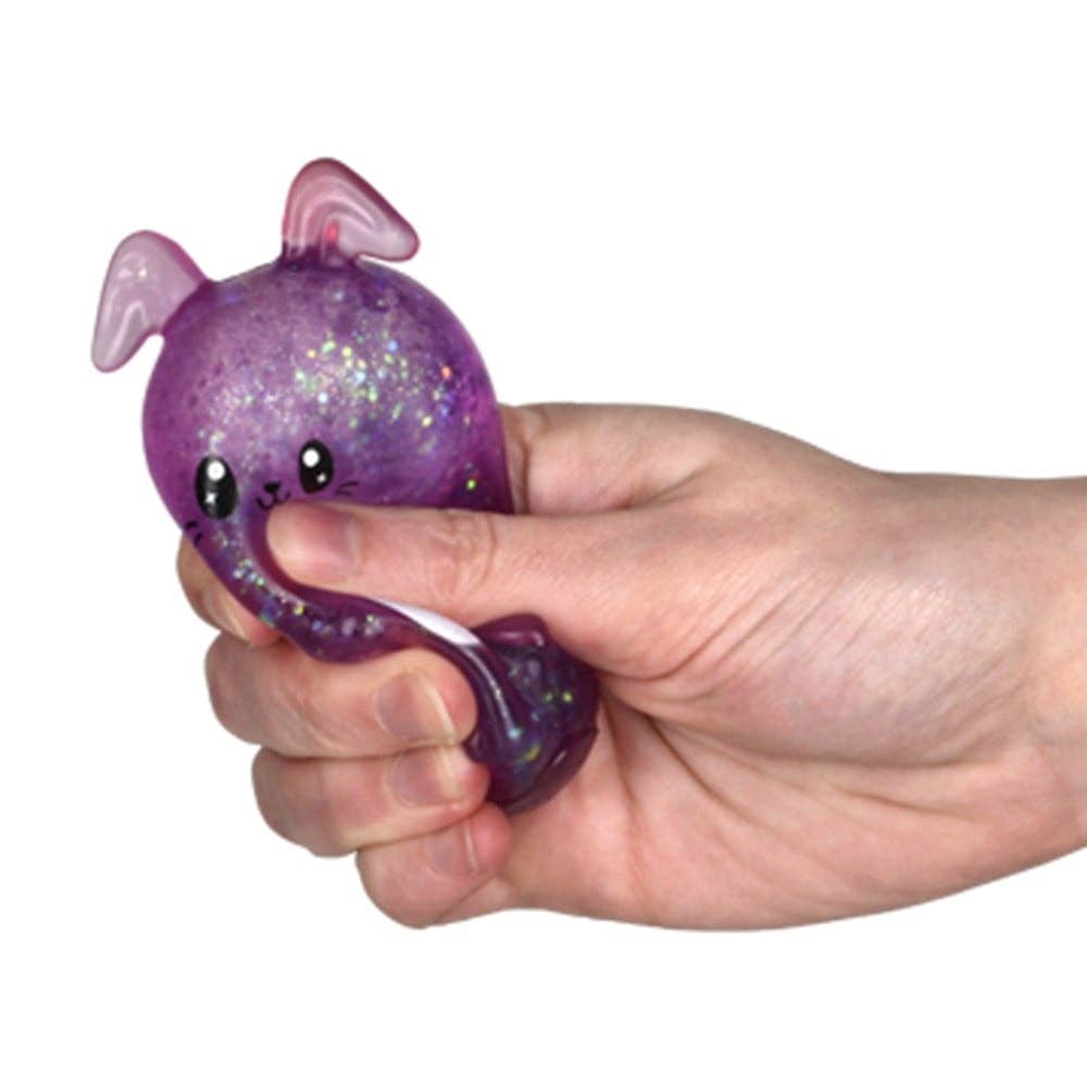 Hand holding a purple glittery bunny toy against a white background