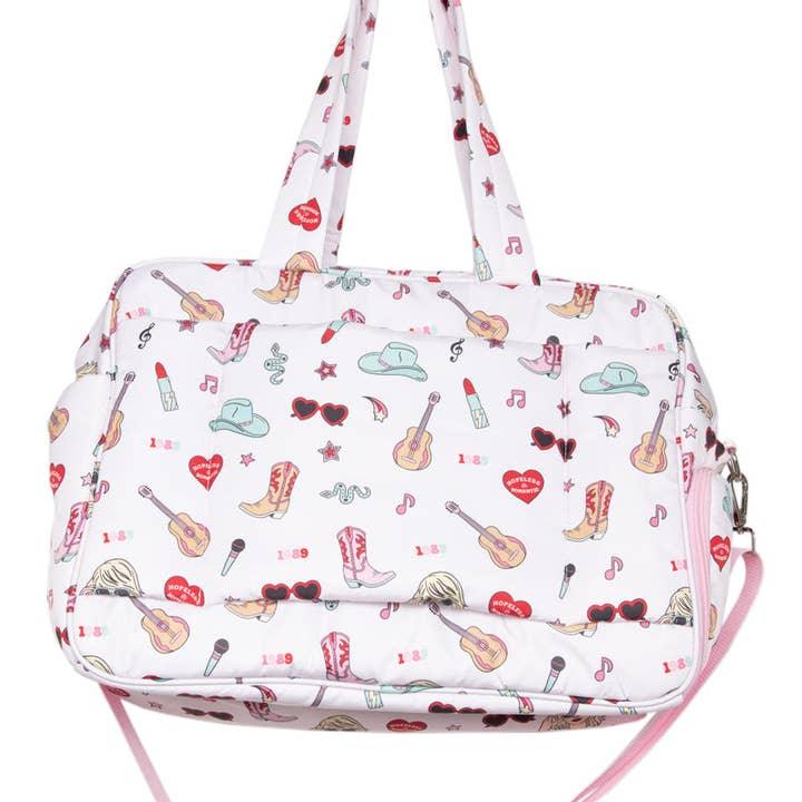 close up of the Taylor Swift inspired print with travel slip pocked over the luggage handle . 