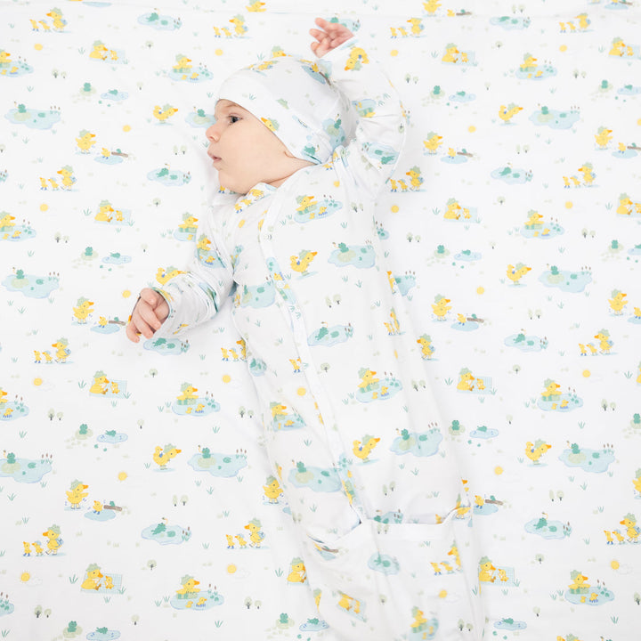 Baby sleeping in a patterned crib sheet with duck designs