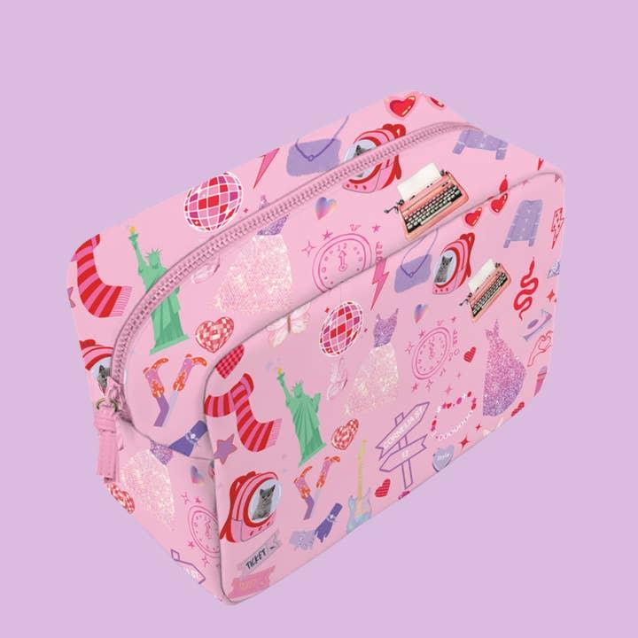 antother view of the pink pouch and Taylor Swift inspired print: dresses from Lover era, statue of liberty, frienship bracelet and disco balls. 