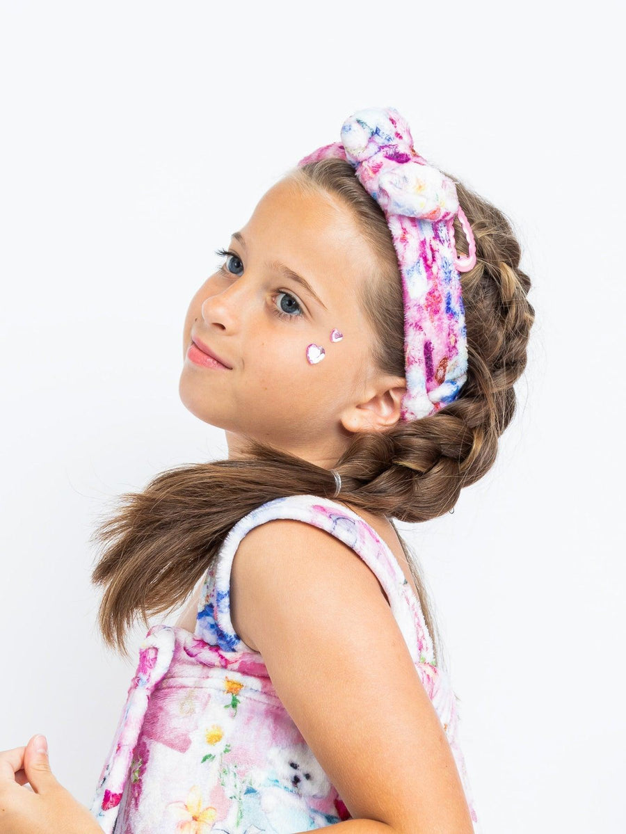young girl modeling the plush spa headband with pop princess icon print. 