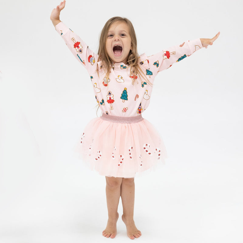 gingerbread cookies holiday themed all over light pink sweatshirt and a light pink tutu with red and white sequin candy canes along the bottom. 