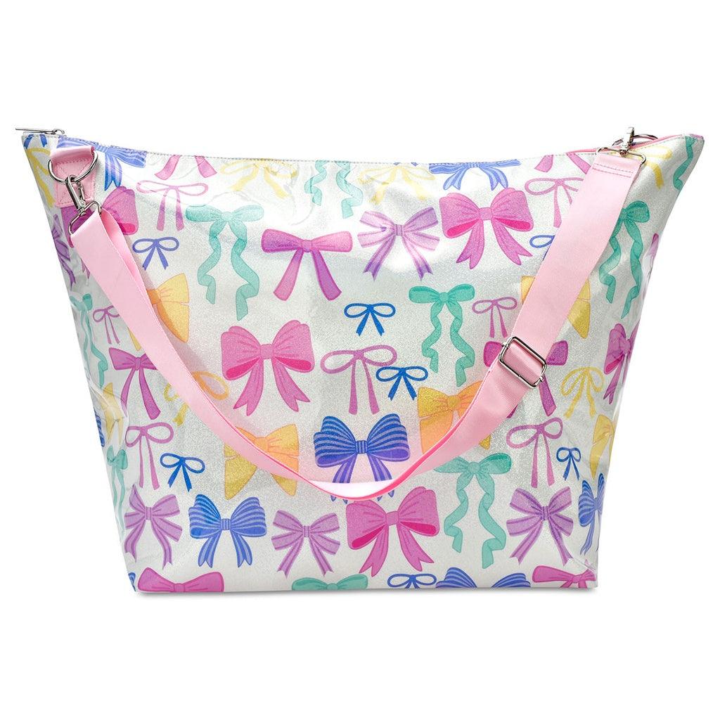 white weekender tote bag with pink shoulder strap for easy carrying. colorful bows all over the tote: pink, yellow, blue, and green 