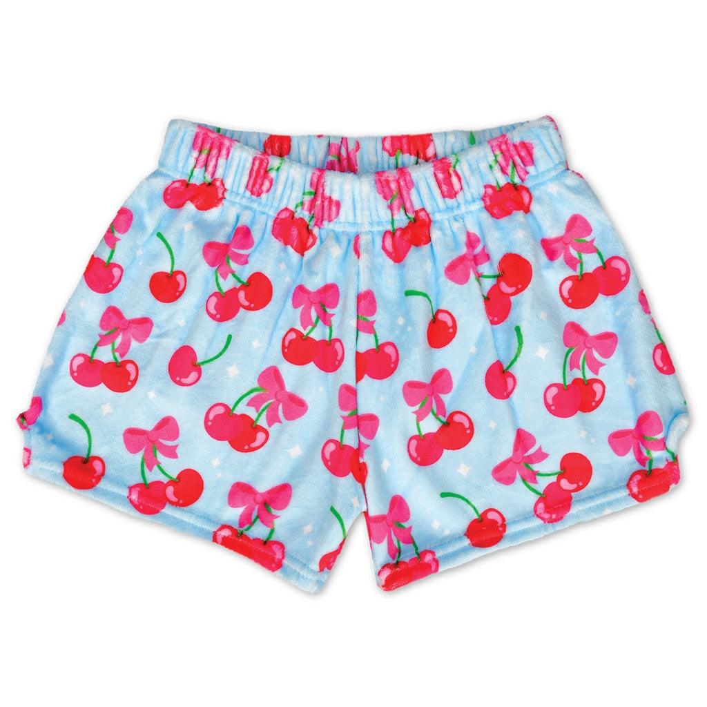 light blue plush shorts with red cherries all over the shorts and a pink bow at the top of the cherries. 